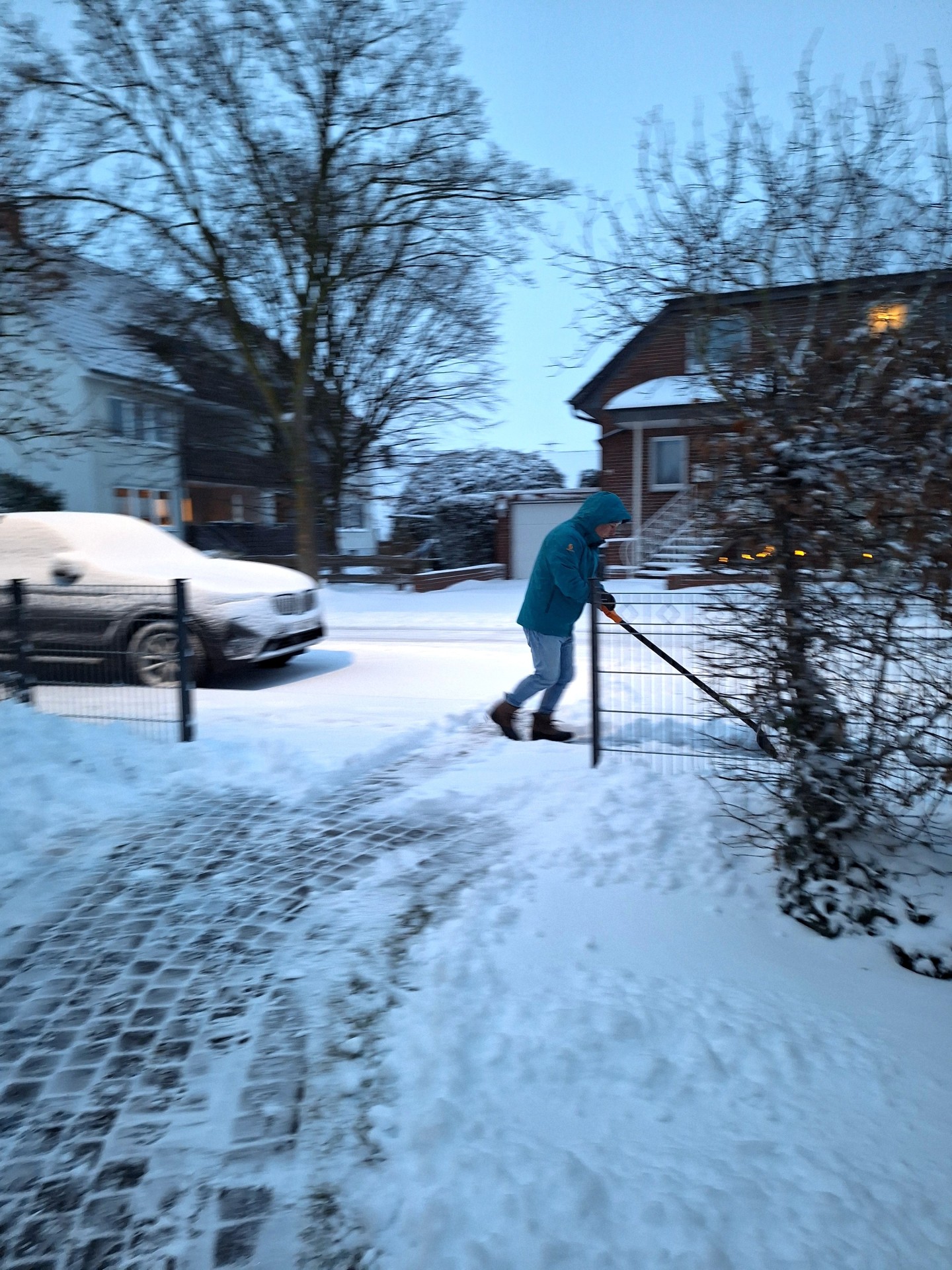Das Foto zeigt einen Mann beim Schneeschieben