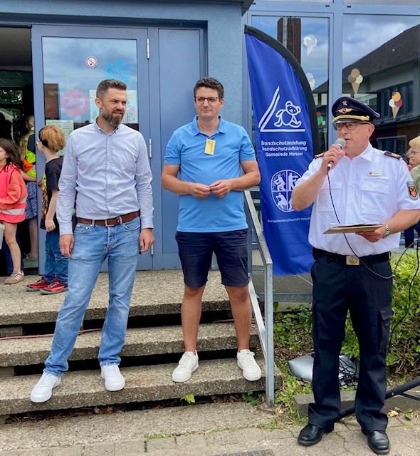 Auf dem Foto sind Marcel Litfin (Bürgermeister), André Hollemann (Schulleiter GS Harsum) und Heiko Bartels (Feuerwehr) im Rahmen der Ehrung zu sehen