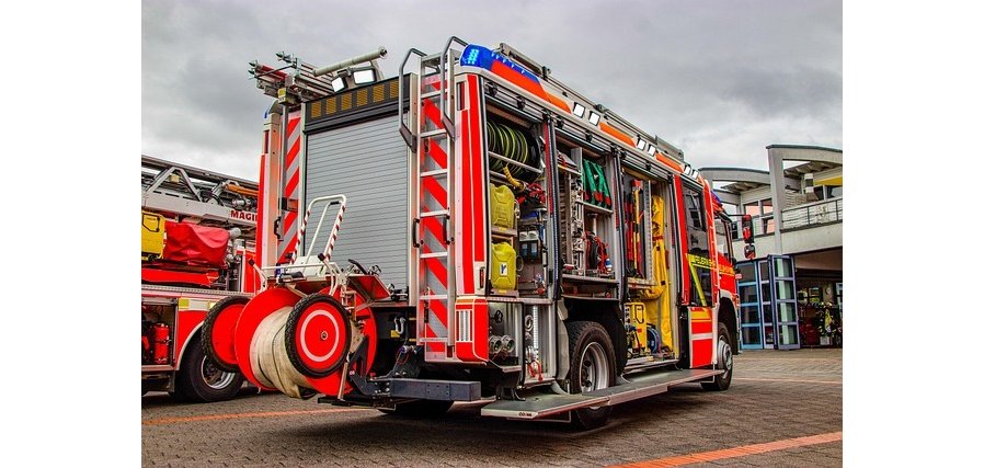 Auf dem Bild ist das Plakat für die Wettkämpfe zu sehen mit Feuerwehrleuten und Daten zum Veranstaltungstag