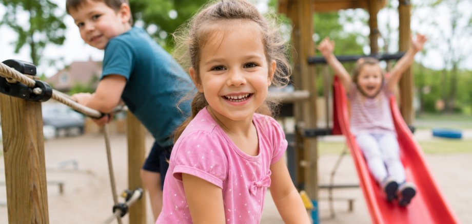 Auf dem Bild sind spielende Kinder auf einem Spielplatz zu sehen.