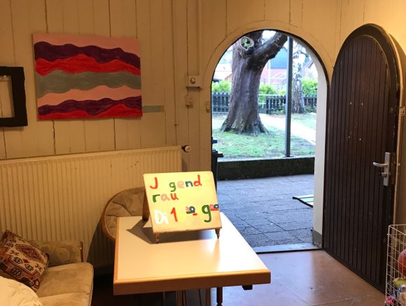 auf dem Foto ist der Eingangsbereich, eine Sitzbank, ein Tisch ein Regal zu sehen