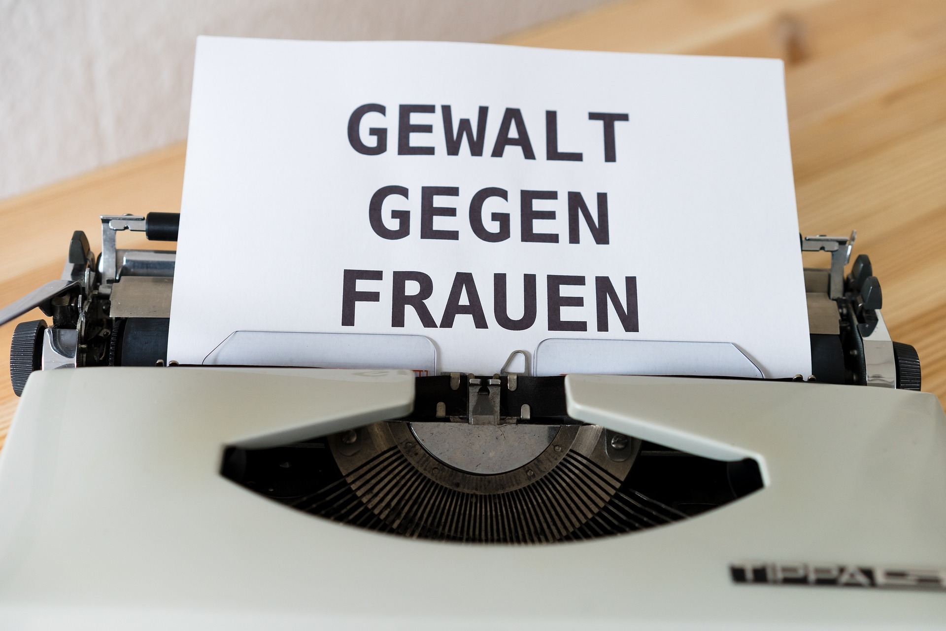Auf dem Bild ist ein Blatt in einer Schreibmaschine zu sehen, auf dem "Gewalt gegen Frauen" steht
