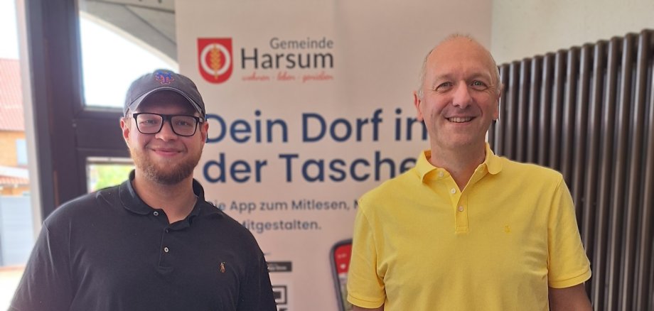 Auf dem Foto ist ein Mitarbeiter des Rathauses und ein Vertreter der Feuerwehr zu sehen, der einen Laptop in der Hand hält