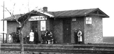 Das schwarzweiß Foto zeigt den Bahnhof und den Bahnsteig in Rautenberg mit Leuten