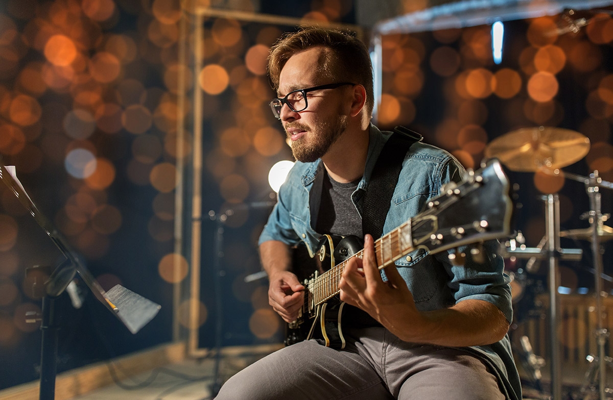 man playing guitar at studio or concert