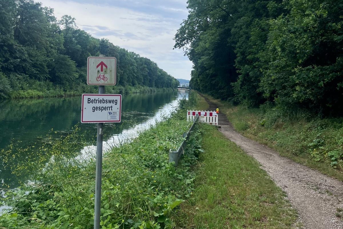 Auf dem Foto ist der Stichkanal mit der Absperrung des Radweges zu sehen